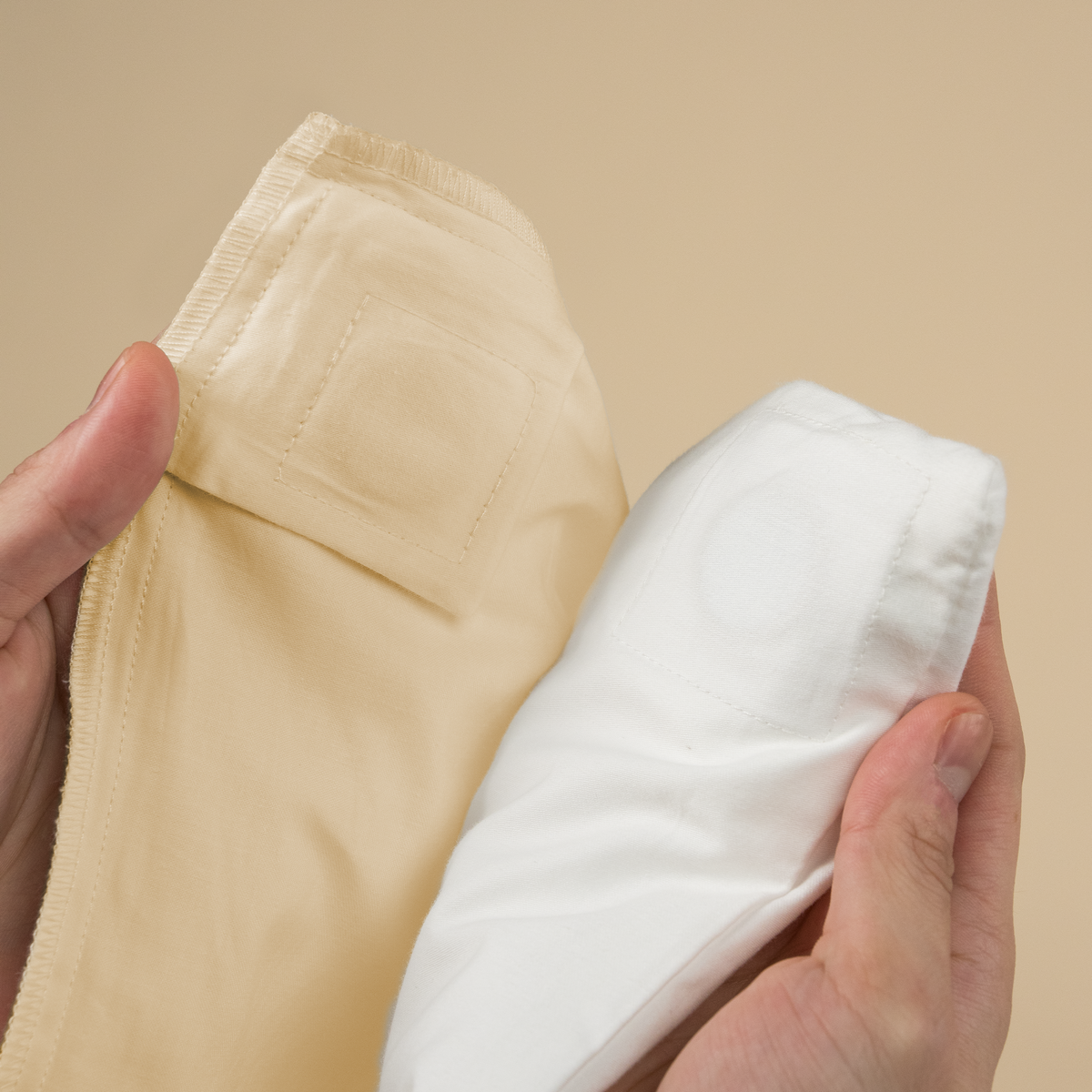 Hands aligning the magnetic corner patches of the duvet cover and insert